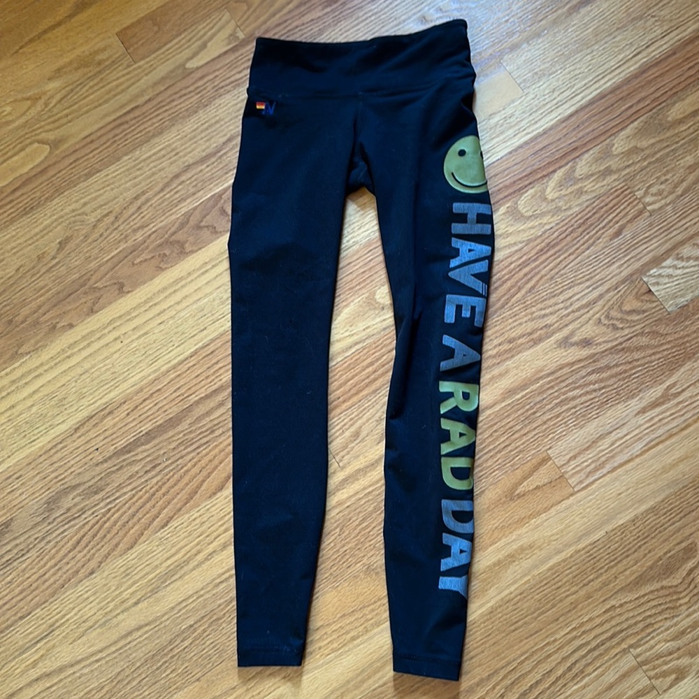 Aviator nation black leggings with “have a rad day” and smiley face on side